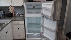 A kitchen with white cabinets, a granite countertop, and a built-in refrigerator with multiple shelves. - GOTL Lovers Chateau Cottage U7 (Geneva)