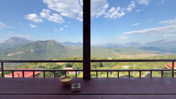 Un balcón con vistas a montañas y un cielo despejado.