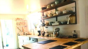 Cozinha com bancadas de madeira, forno embutido e cafeteira.