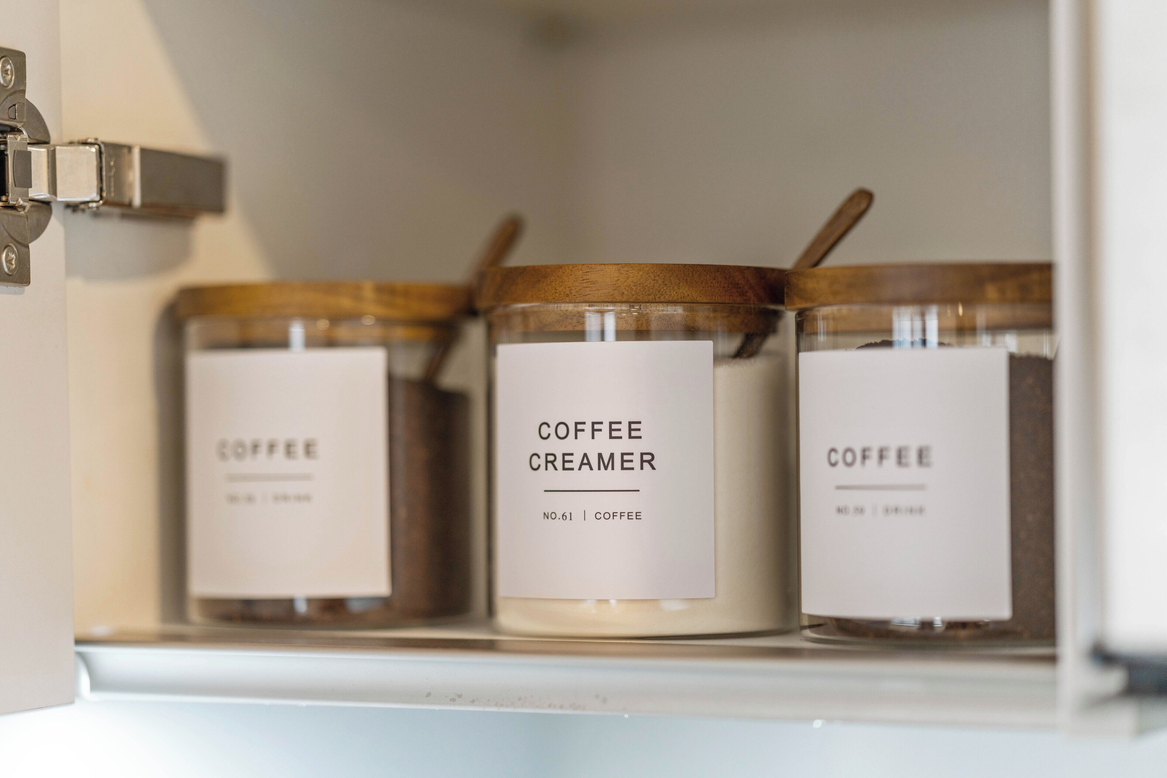 Tres pots etiquetats com "Llet per a cafè" a una estant.