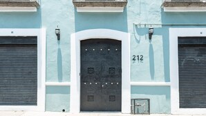 Ein Gebäude mit einer geschlossenen schwarzen Tür, der Hausnummer „212“ an der Wand und zwei geschlossenen Garagentoren.