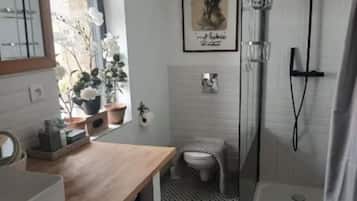 Een douche, handdoeken, zeep, toiletpapier