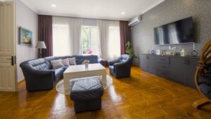 Una sala de estar moderna con un conjunto de sofá, una mesa de centro y un televisor montado en la pared.