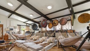 A rustic room with hammocks, a large bed, and hanging pottery. - Clover at Gorslwyd - Sound Retreat (Cardigan)
