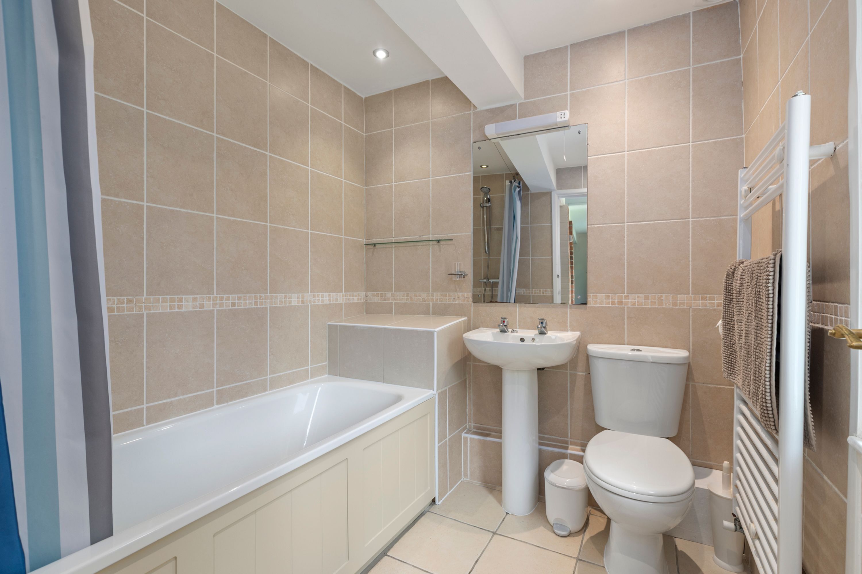 Een moderne badkamer met een bad, wastafel en toilet.