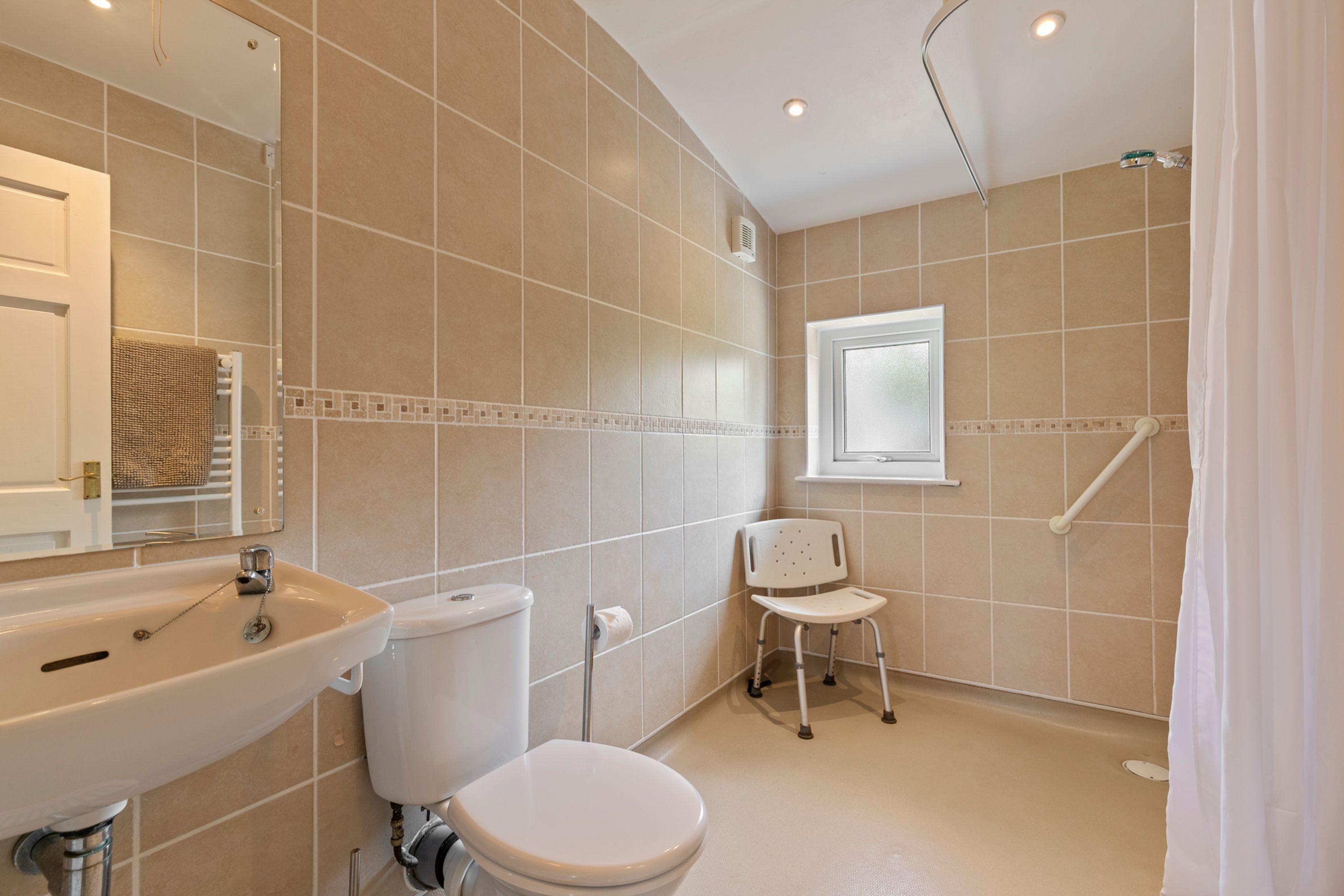 A bathroom with a sink, toilet, and a shower area.