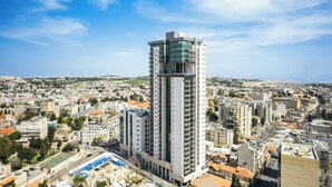 A high-rise building with a modern design, surrounded by a densely populated urban area.