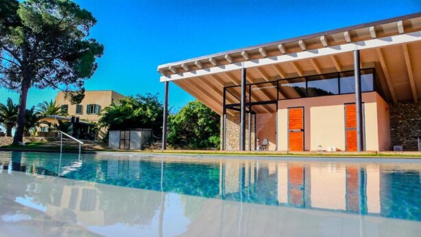 Un bâtiment moderne avec une piscine à l’avant.