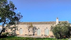 A stone building with a tiled roof, a chimney, and two arched doorways. - Masseria PietraViva - Altamura (Altamura)