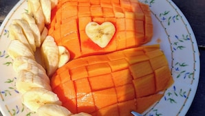 A plate with sliced mango and banana arranged on a decorative plate. - Shambhala Ecological Suite by the Sea between Paraty and Ubatuba (Camburi Ubatuba)