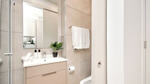 A modern bathroom with a toilet, sink, and mirror.