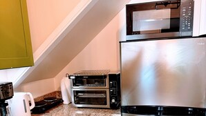 A kitchen with a stainless steel refrigerator, a microwave, and two built-in ovens.