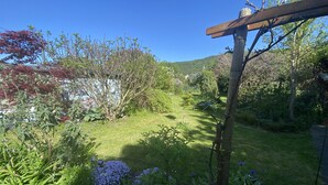 Un jardin agrémenté de diverses plantes et d’une pergola en bois.