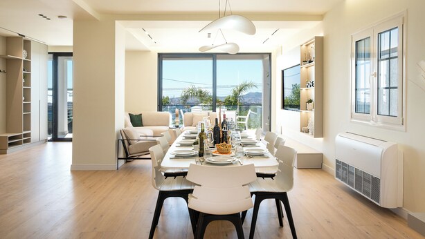 A modern dining area with a long table set for a meal, large windows offering a view of the outdoors, and a bright, airy atmosphere. - Villa Cosmo (Rrashbull)