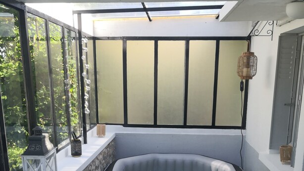 Un bain à remous installé dans un coin, avec un mur en pierre et une fenêtre.