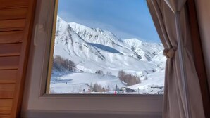 A window with a view of snow-covered mountains.