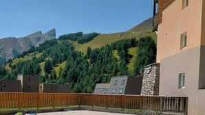 A swimming pool with a view of a mountain and a building with a stone facade.