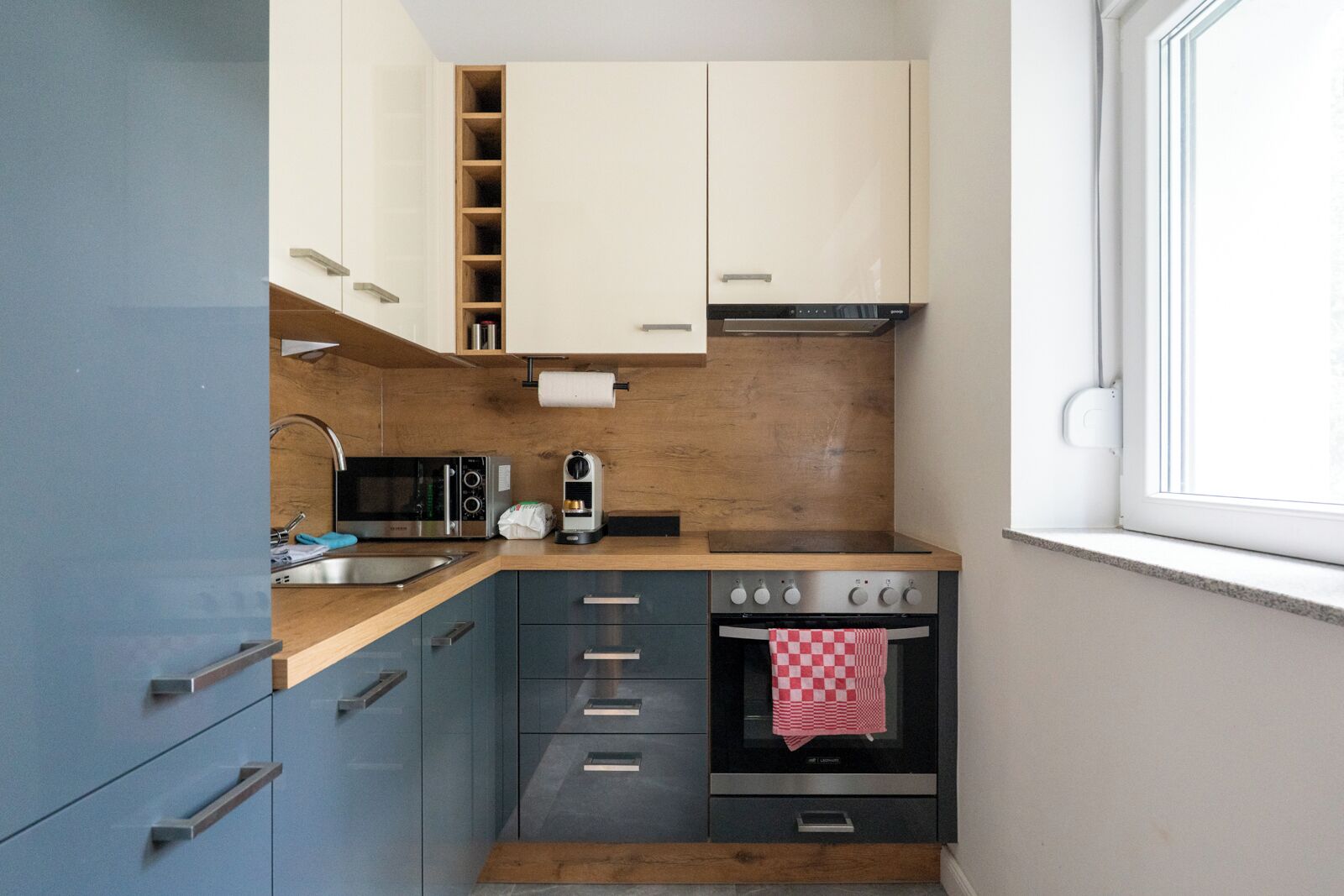 A compact kitchen with a built-in oven, a microwave, and a coffee maker.