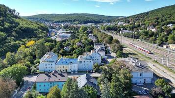 Un quartier résidentiel avec des maisons, une ligne de chemin de fer et un paysage vallonné.