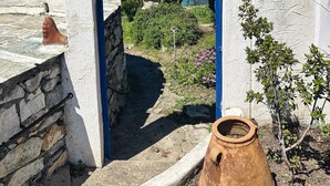 A rustic stone archway leading to a scenic view of a coastal area with a clear blue sky. - Villa Panorama, the magic of Skiathos in a family villa with history (Skiathos)