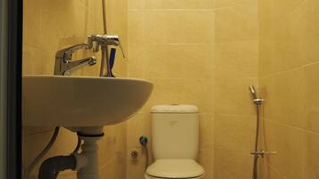 Un baño pequeño con inodoro, lavamanos y ducha.