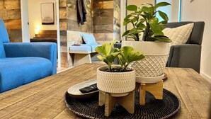 A wooden table with two potted plants and a remote control.
