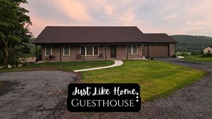 A two-story stone house with a garage, a driveway, and a well-maintained lawn. - Just Like Home, brand new 2 bedroom rancher with full kitchen. (Mohnton)