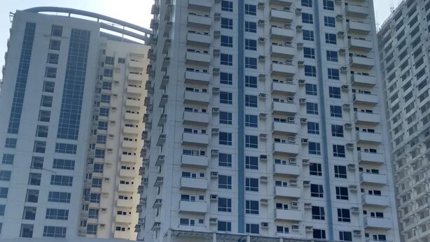 A high-rise building with multiple floors, large windows, and balconies. - Studio Unit with Balcony in Manila (Manila)