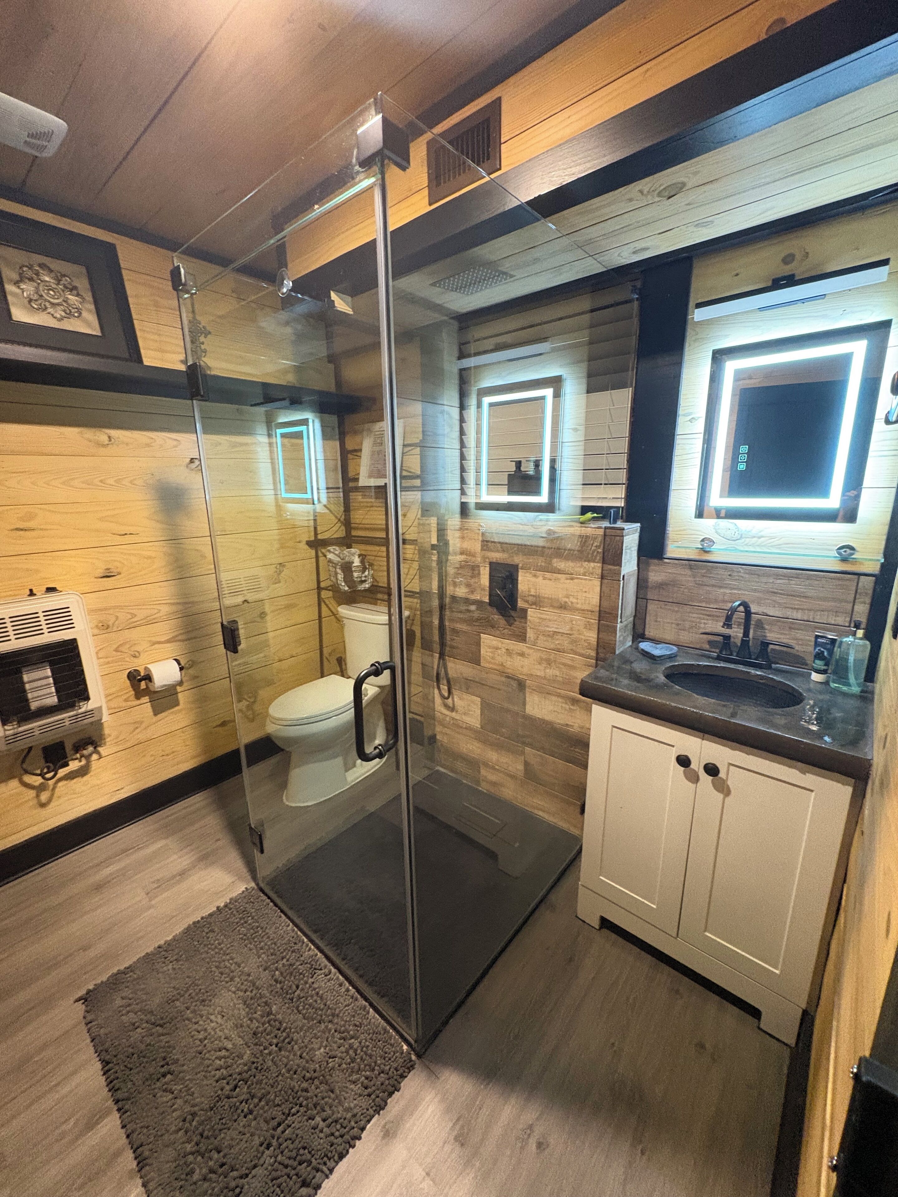 Une salle de bain moderne avec une douche à parois de verre, des toilettes et un lavabo avec un miroir.