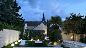 A swimming pool with a stone border, surrounded by a well-manicured lawn and a variety of trees. - Comfortable country house with heated swimming pool in Eure et Loire (Tillay-le-Péneux)