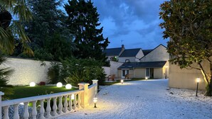 A gravel driveway leading to a house with a white fence and decorative lights. - Comfortable country house with heated swimming pool in Eure et Loire (Tillay-le-Péneux)