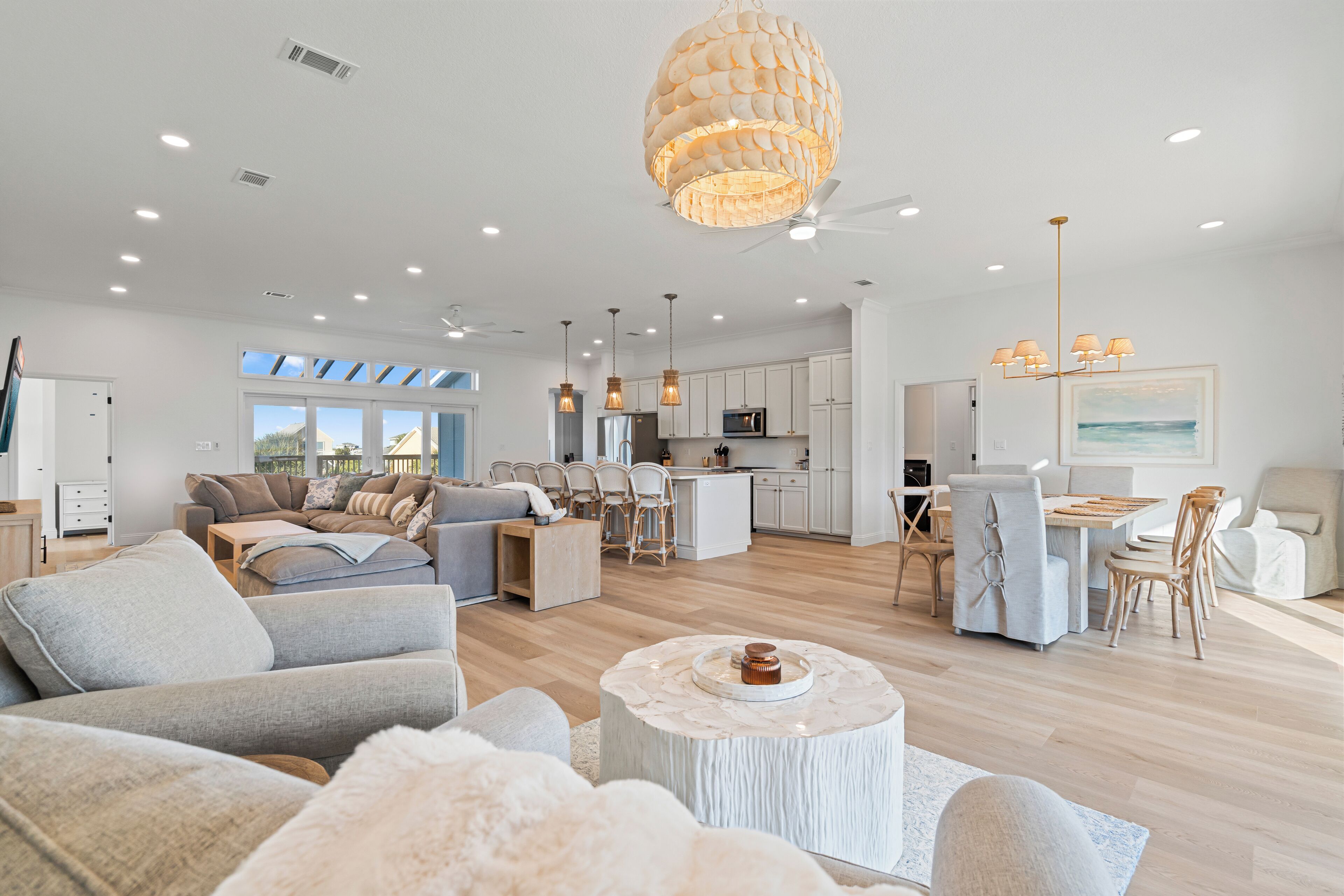 A spacious living area with a modern kitchen, dining area, and a large window providing natural light.