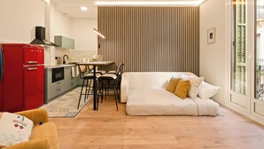 Un espace de vie compact comprenant un coin cuisine, un canapé et un coin repas.