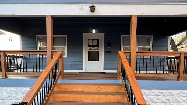 A wooden staircase leading to a front door with a small porch area.