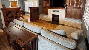 A living room with a sectional sofa, wooden coffee table, and a fireplace.