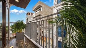 A balcony with a view of a building, a railing, and a potted plant. - T P Villa (Da Nang)