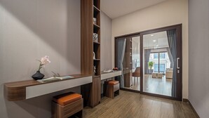 A modern room with a wooden console table, a bench, a bookshelf, and a sliding glass door leading to a balcony. - T P Villa (Da Nang)