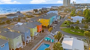 A residential area with colorful houses, a swimming pool, and a view of the ocean.