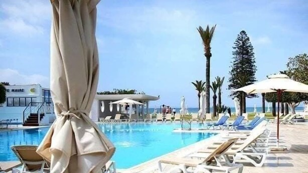 A poolside area with lounge chairs, a pool, and a building labeled "MAURE". - Hôtel Les Pyramides Club  (Nabeul)