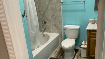 A bathroom with a bathtub, toilet, and sink.