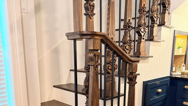 Una scala in legno con ringhiere elaborate e gradini scuri.