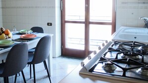 Une cuisine équipée d’une cuisinière à gaz, une table à manger avec des chaises et une fenêtre donnant sur un beau paysage.