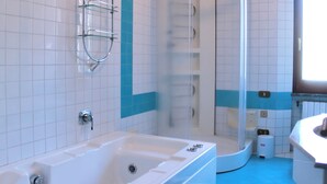 Une salle de bain équipée d’une baignoire, d’un espace douche et d’un lavabo.