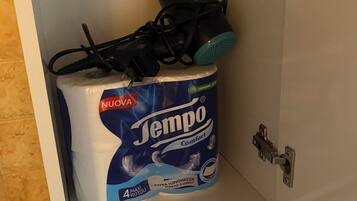 A toilet paper roll labeled 'Tempo Comfort' in a cabinet.
