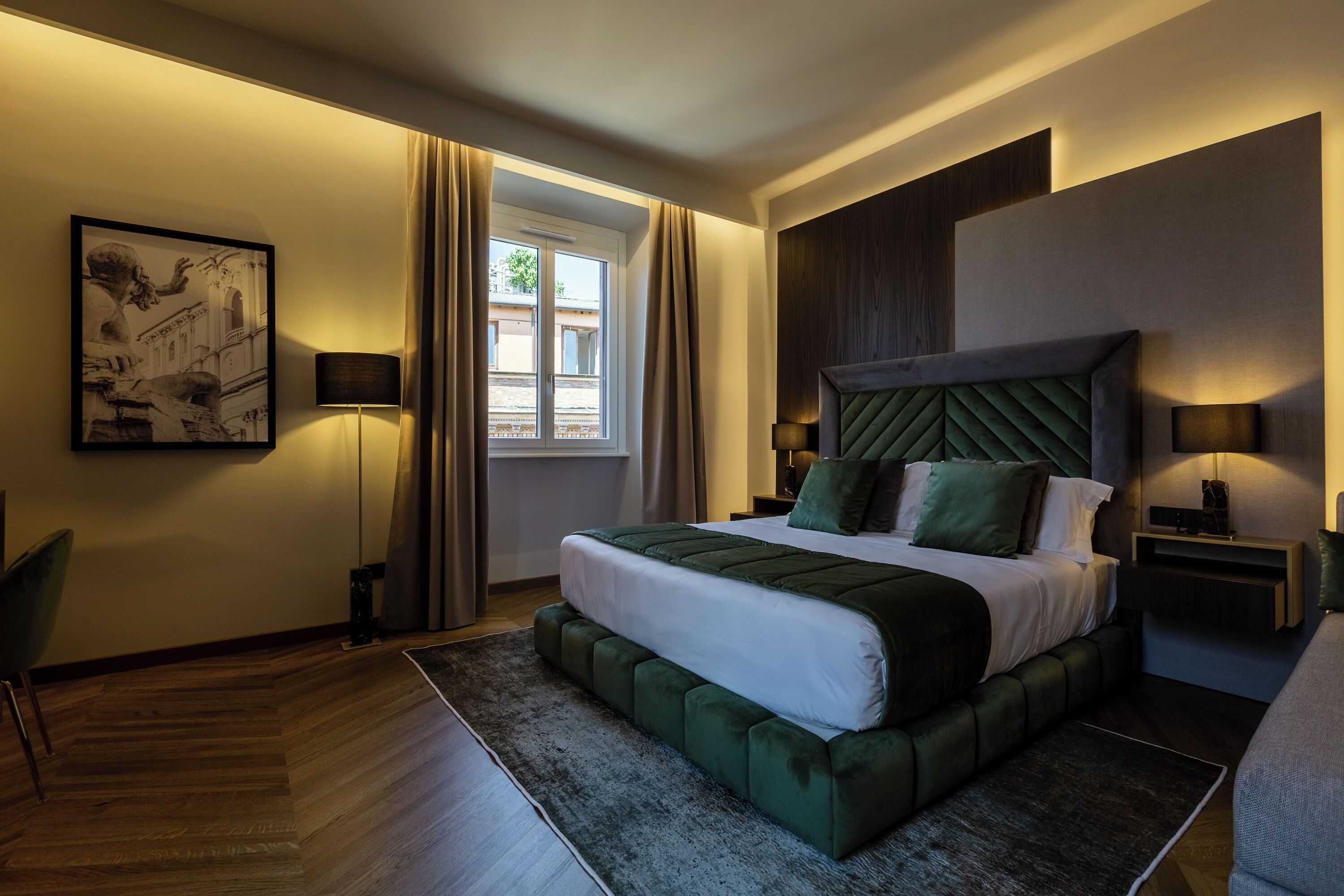 Habitación de hotel moderna con una cama grande, una mesita auxiliar, una silla y vistas al exterior.