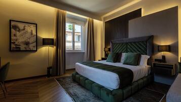 Habitación de hotel moderna con una cama grande, una mesita auxiliar, una silla y vistas al exterior.