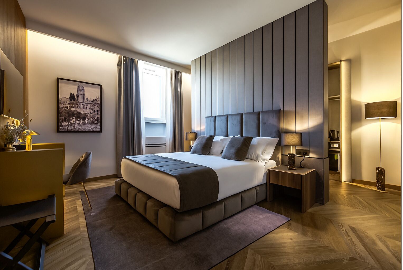 Une chambre d’hôtel moderne avec un grand lit, un bureau et une vue sur le paysage urbain.