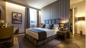 Une chambre d’hôtel moderne avec un grand lit, un bureau et une vue sur le paysage urbain.