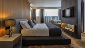 A modern hotel room with a large bed, a TV mounted on the wall, and a bedside table with a lamp. - Fontart Tritone  (Rome)