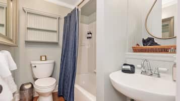 Une salle de bain avec des toilettes, une douche et un lavabo.